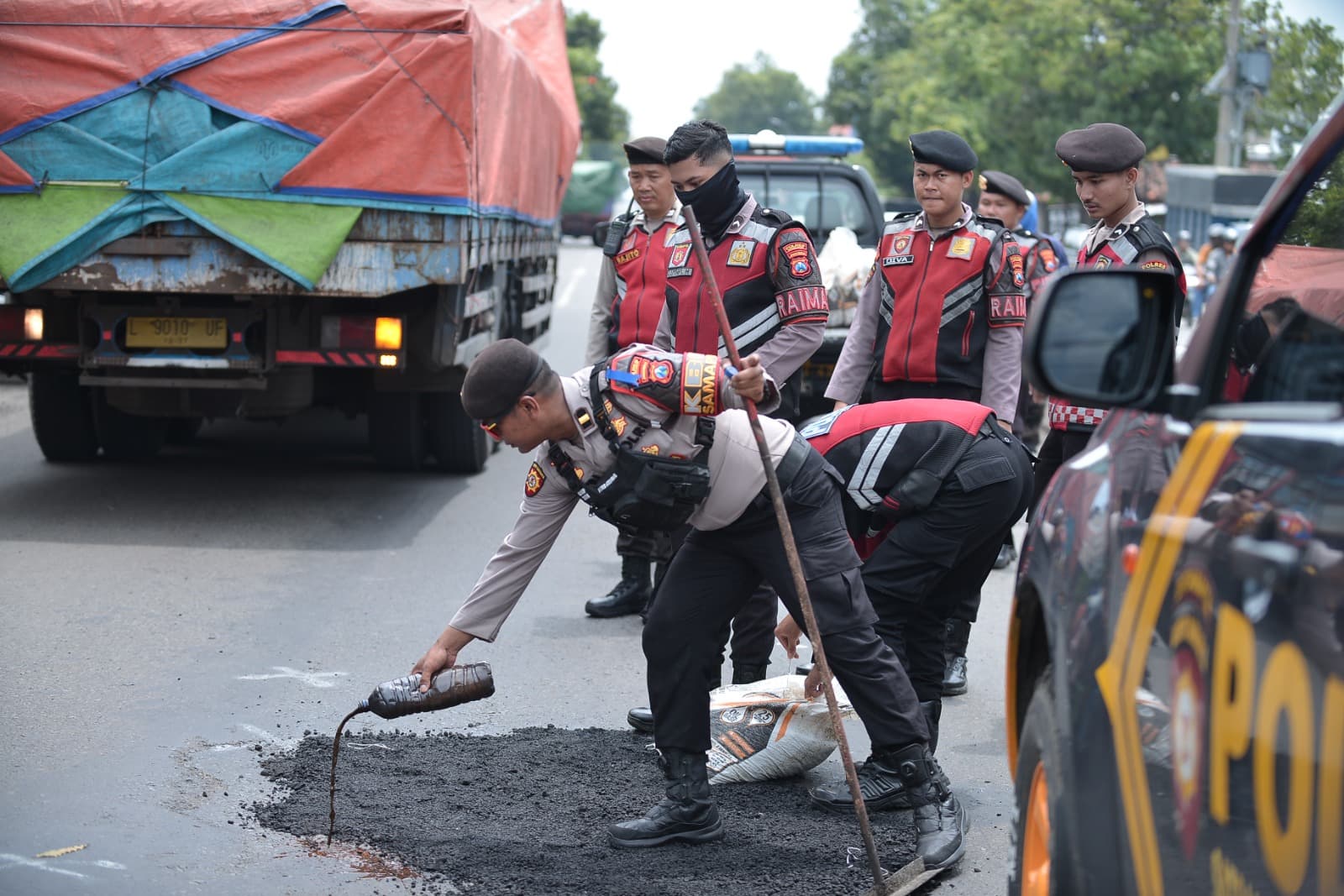 Aksi Kepedulian Anggota Polres Situbondo Patroli Sambil Tambal Jalan Berlubang