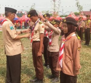 Kak Sudarminto ketua LPK Kwarcab Surabaya menyematkan tanda peserta Raimuna Cabang 2025